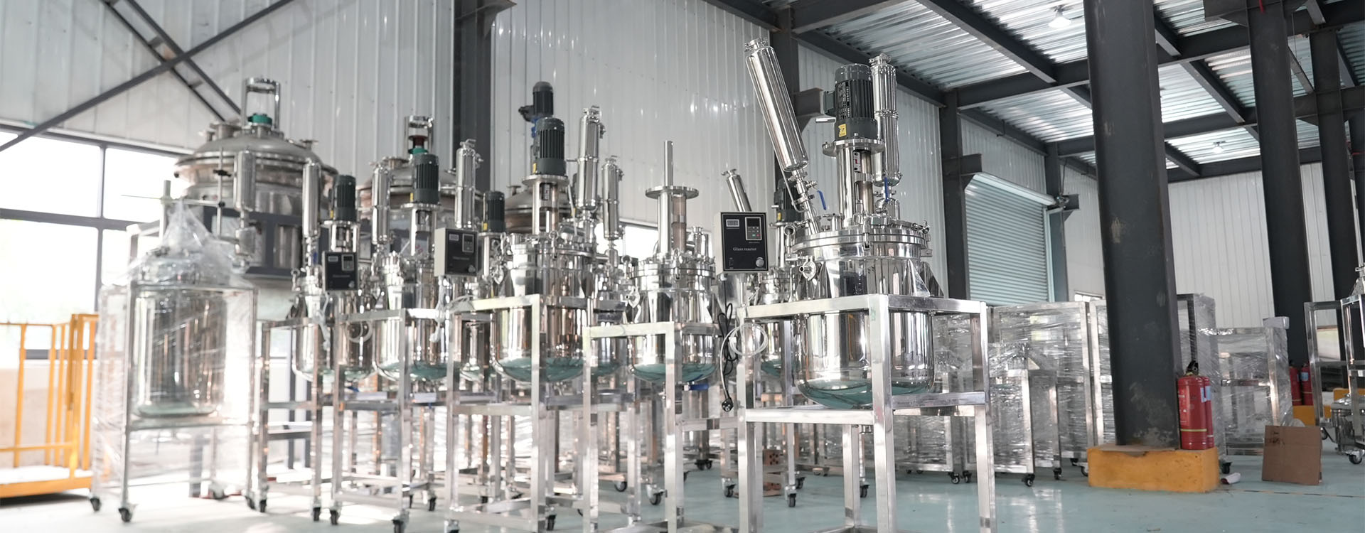 Stainless steel and glass reactor units staged on the UnionClay factory floor before inspection